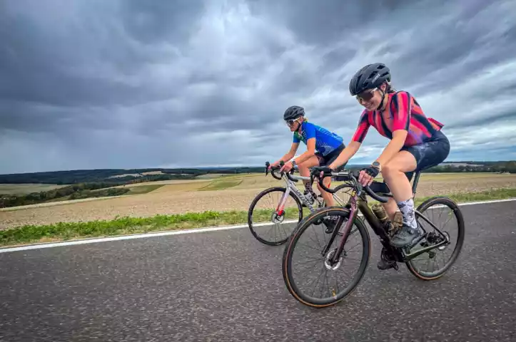 Twee wielrenners fietsen over een rustige weg door het heuvelachtige landschap van de Hunsrück