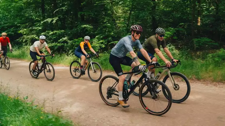 Groep gravelbikers fietst door het Kondelwald en geniet van de mooie paden.